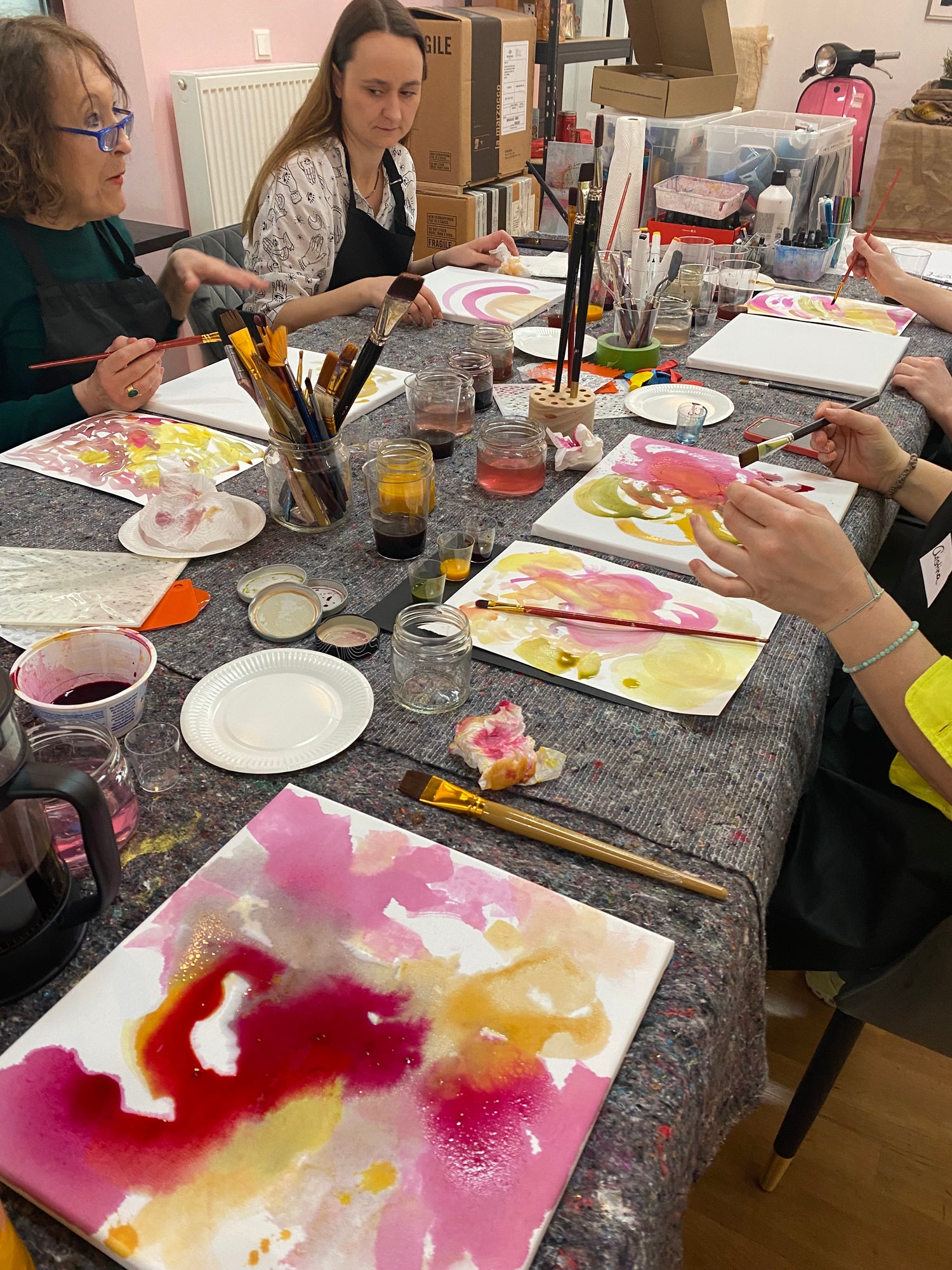 abstract art workshop painting withh all participants in a cafe people painting
