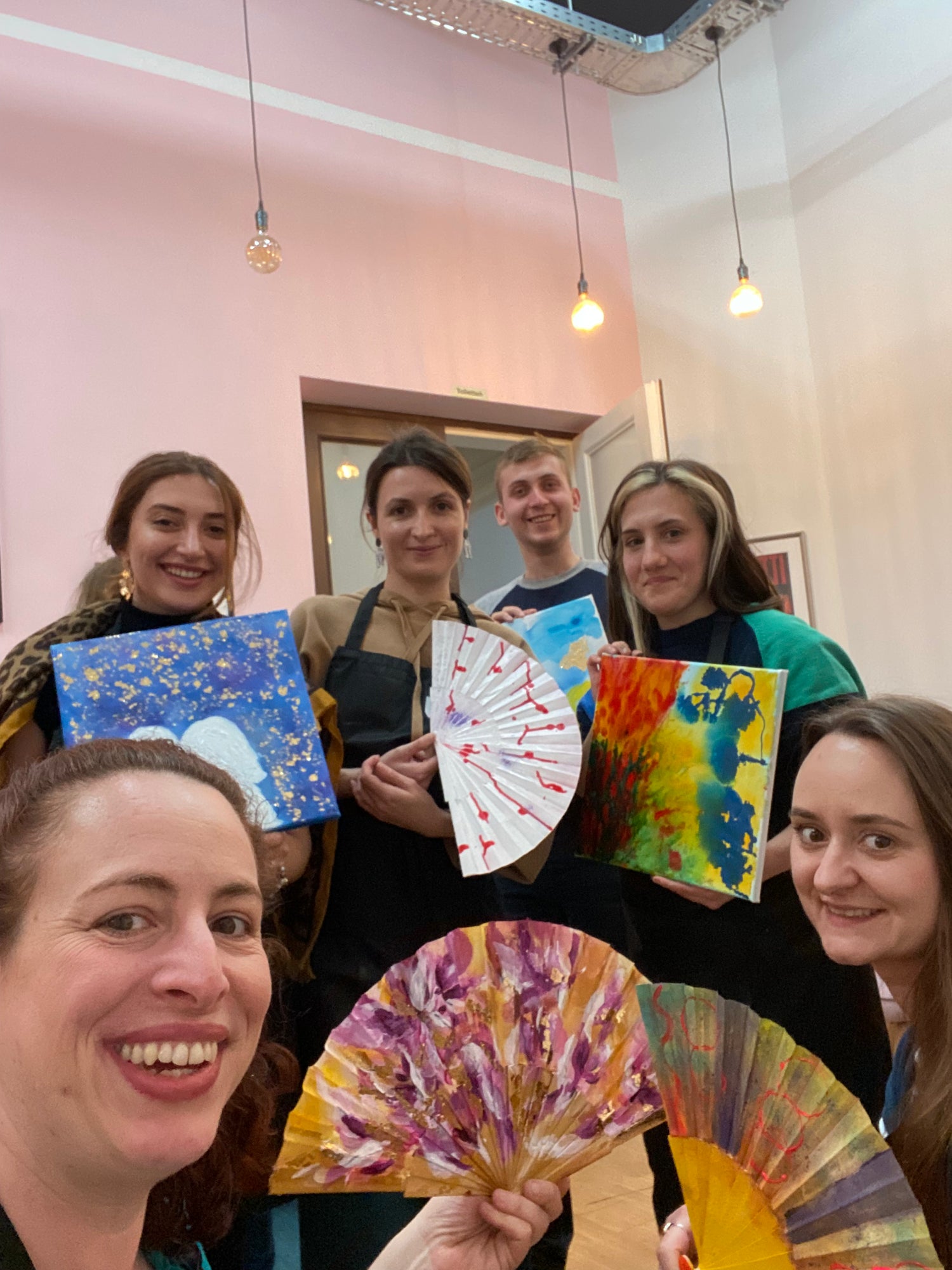 abstract art workshop painting group photos with all participants in a cafe